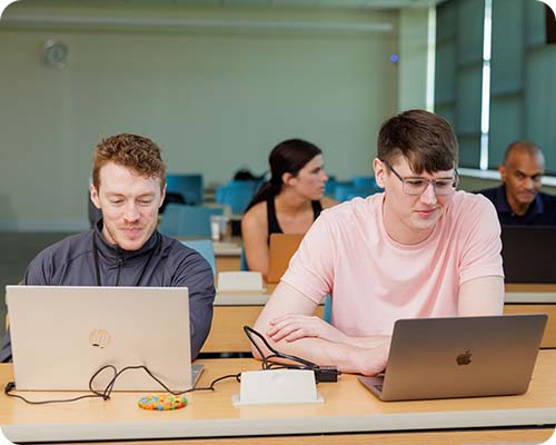Students sitting at tables on computers