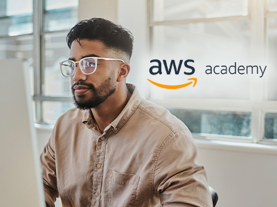 Man at a monitor with AWS Academy logo.