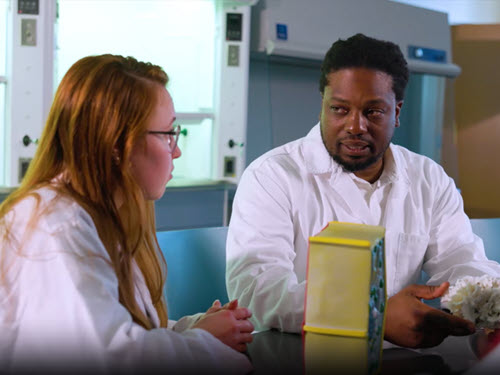 science professor talking to a student in a lab