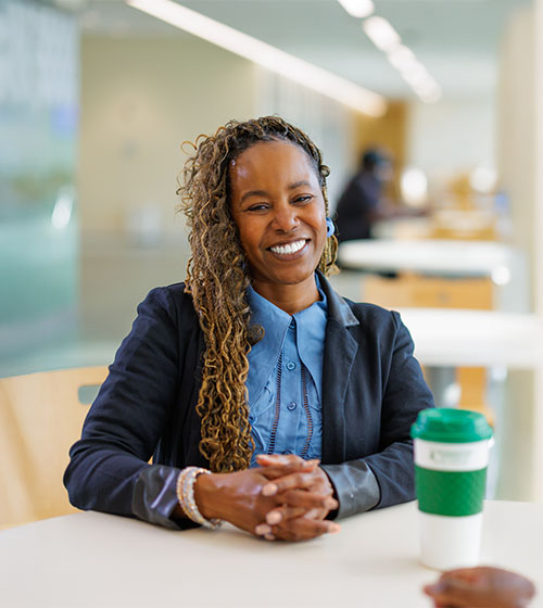 Two staff members smiling on WilmU campus.