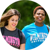 People walking on campus with wilmington university shirts. 