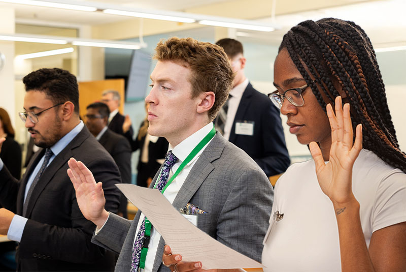 Students raising their hands to pledge