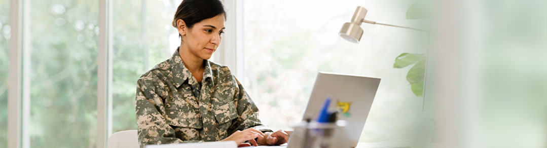 Student soldier typing on a laptop